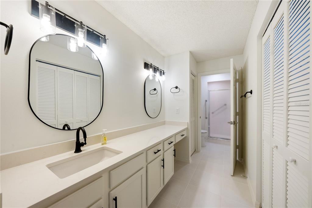 An empty bedroom features white walls, a vaulted ceiling, a ceiling fan, and hardwood floors — 9064 SW 91ST CIRCLE, OCALA, FL
