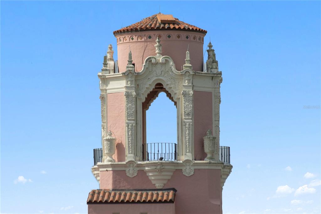 A pink, ornate architectural tower with arched openings and a tiled roof against a blue sky — 700 BEACH DRIVE NE UNIT 603, ST PETERSBURG, FL