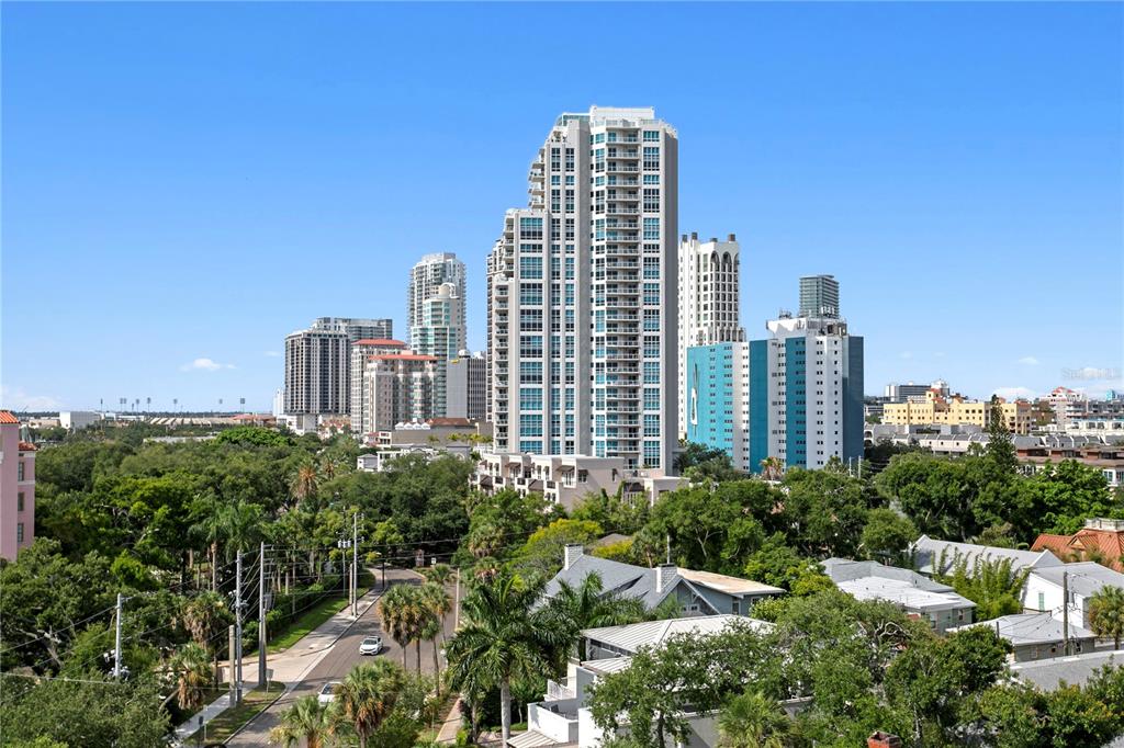 A high-angle view shows a city skyline with tall residential towers above lush green trees — 700 BEACH DRIVE NE UNIT 603, ST PETERSBURG, FL
