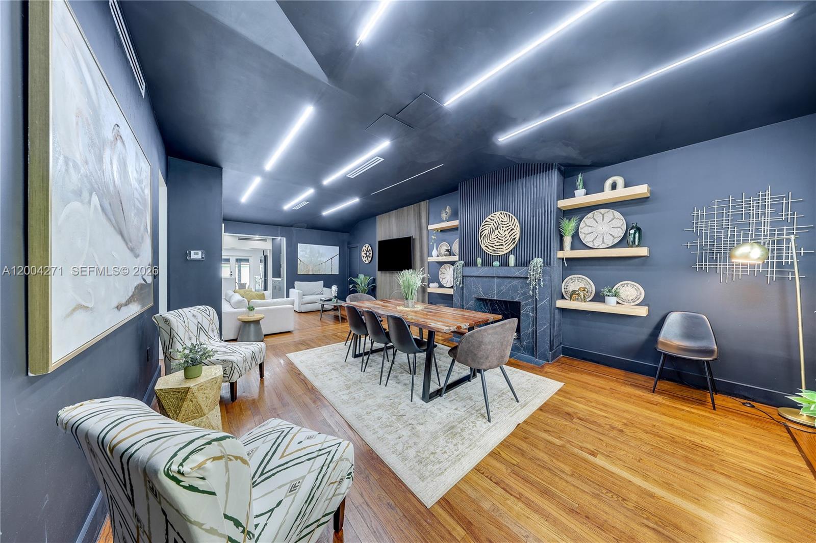 A dining room features dark blue walls, a fireplace, and linear ceiling lighting — 2612 SW 12th St, Miami FL 33135, MIAMI, FL