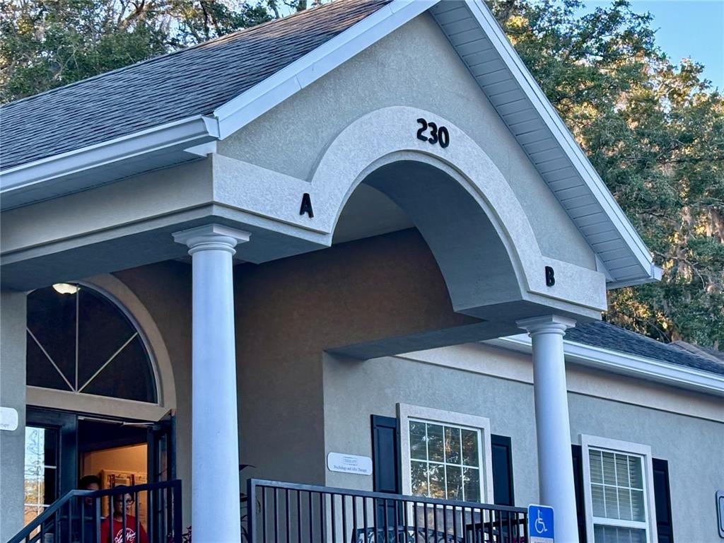 The exterior of a building features a covered entrance with columns and the number 230 — 230 NW 76TH DRIVE UNIT B, GAINESVILLE, FL