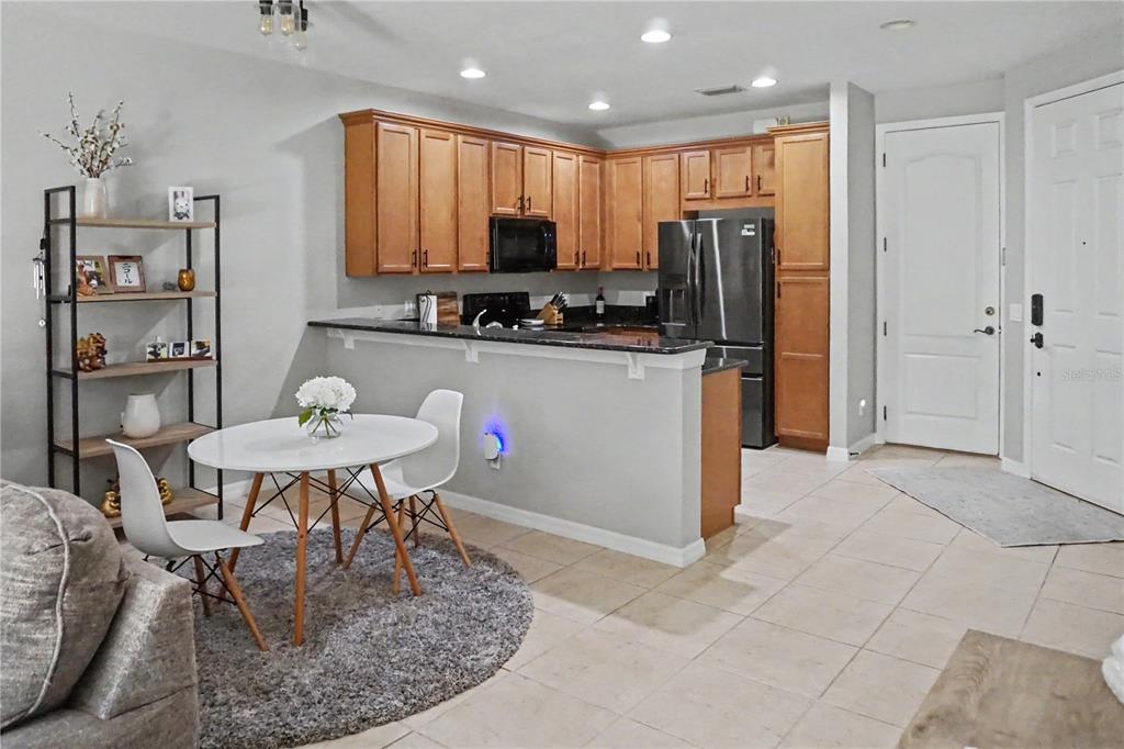 A kitchen with wood cabinets and a breakfast nook featuring a round table and chairs — 1828 GARDEN SAGE DRIVE, OVIEDO, FL