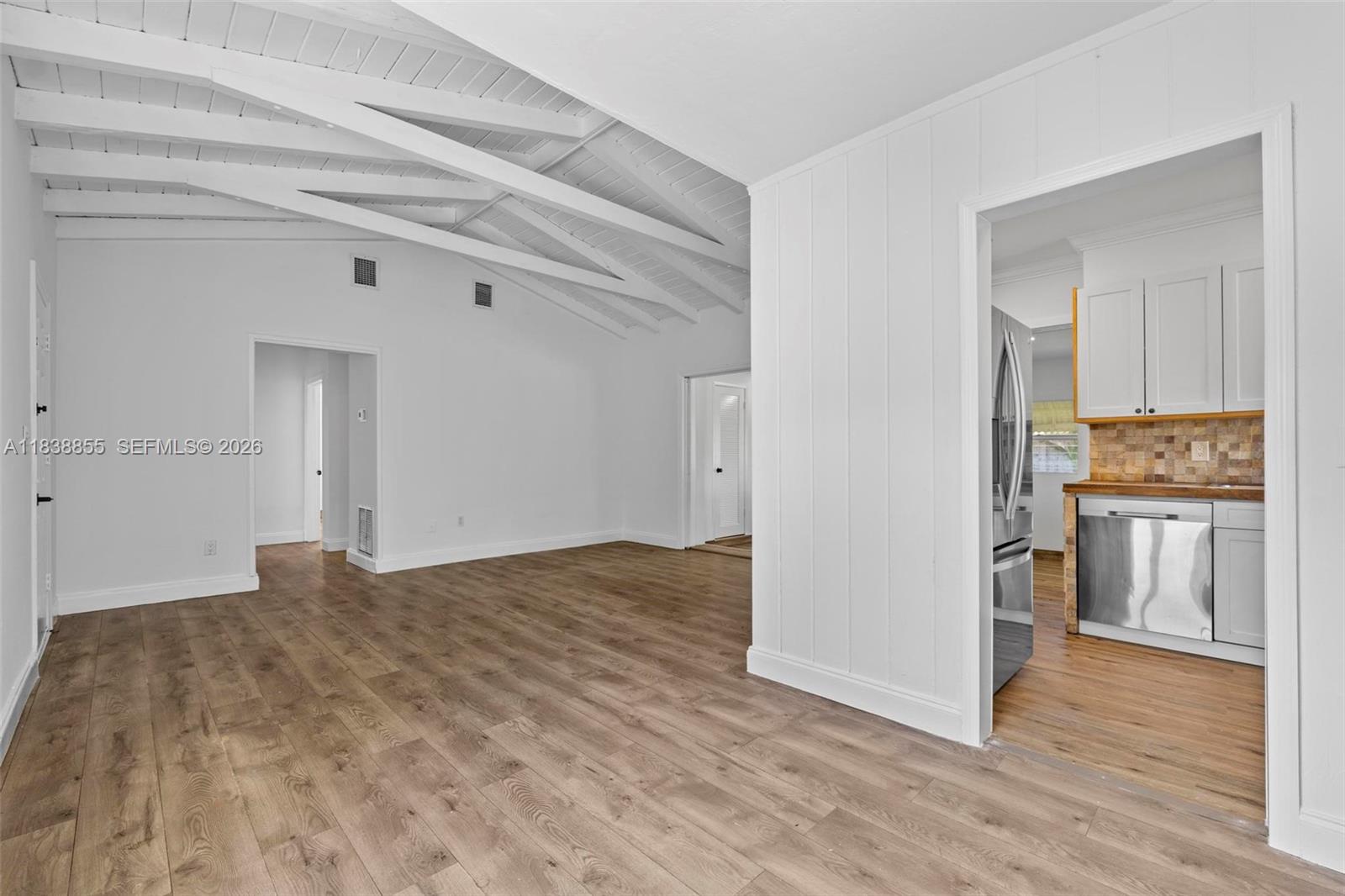 An interior view shows a living area with vaulted ceilings and an adjacent kitchen — 738 Fernwood Rd, Key Biscayne FL 33149, KEY BISCAYNE, FL