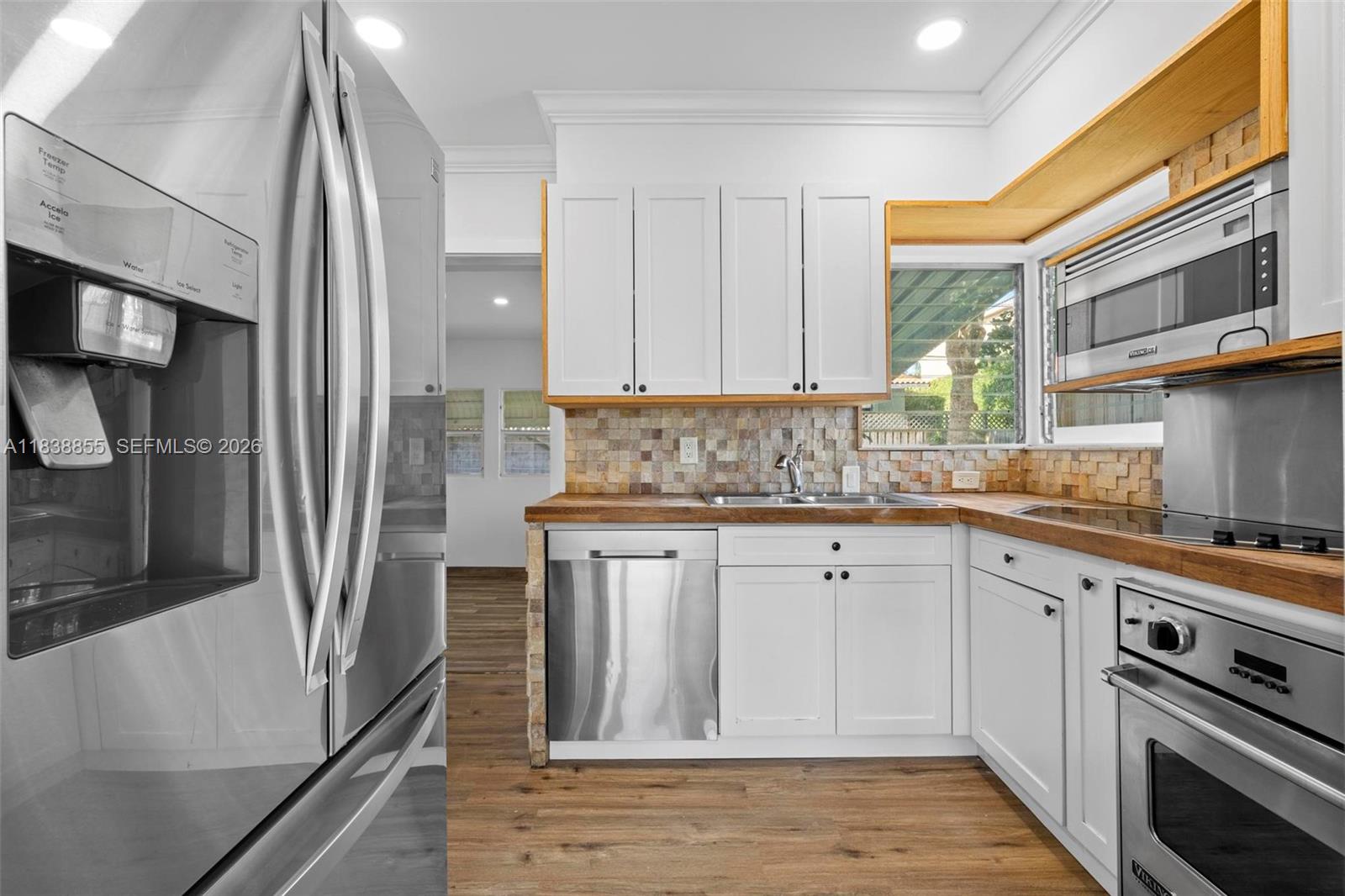 A kitchen features white cabinets, wood countertops, stainless steel appliances, and a tiled backsplash — 738 Fernwood Rd, Key Biscayne FL 33149, KEY BISCAYNE, FL