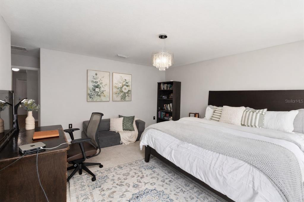 A bedroom features a large bed, a desk with a chair, and a small sofa — 7327 LUMBER PORT DRIVE, RUSKIN, FL