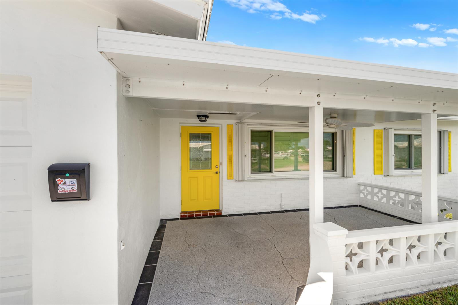 A white house exterior features a bright yellow front door and a covered concrete porch — 2198 SW 12th Avenue, Boynton Beach FL 33426, BOYNTON BEACH, FL