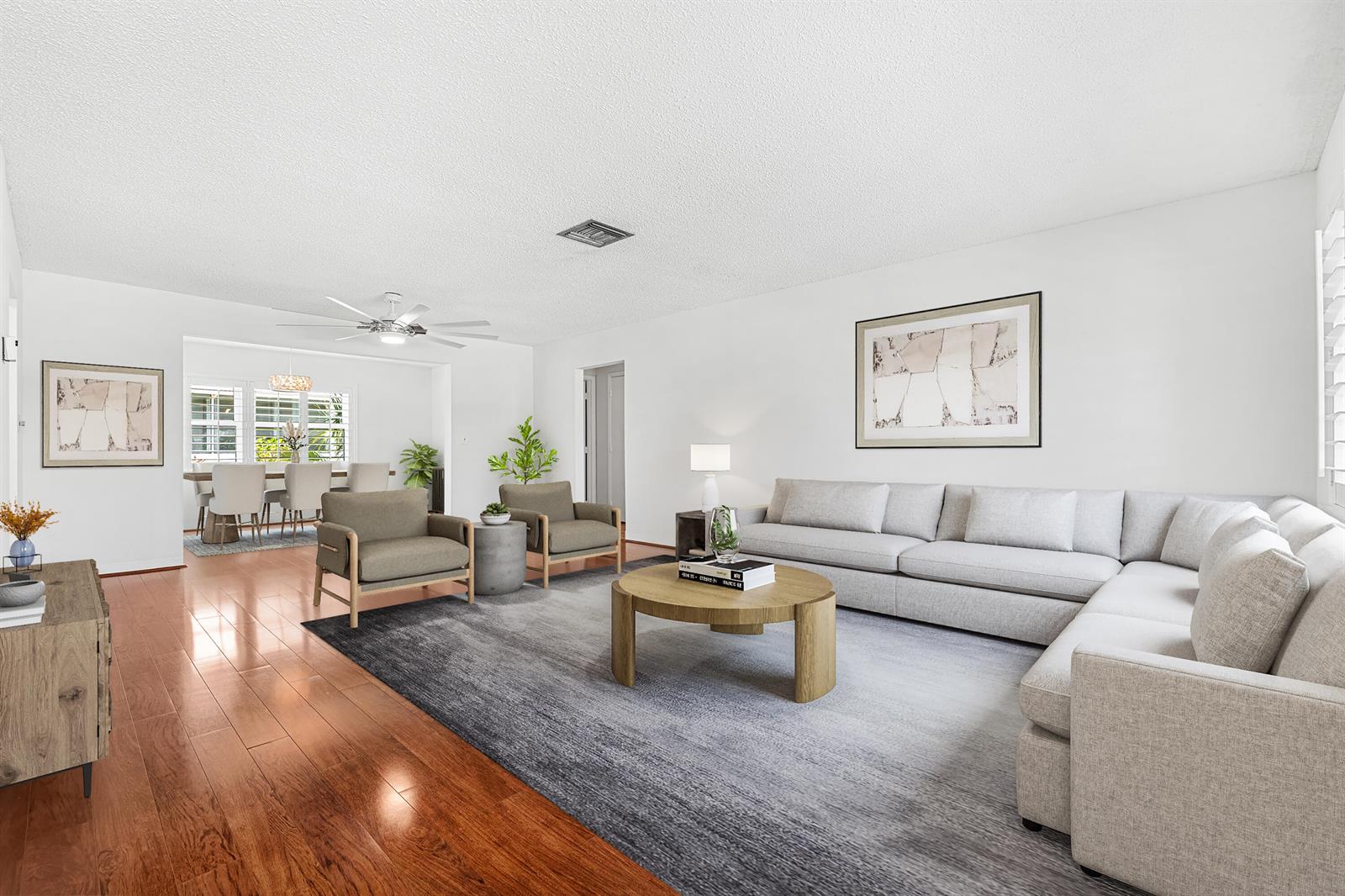 A living room with hardwood floors, a large area rug, a sectional sofa, and chairs — 2198 SW 12th Avenue, Boynton Beach FL 33426, BOYNTON BEACH, FL