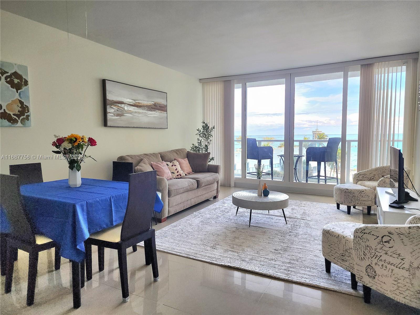 A living and dining area features a blue tablecloth, beige sofa, and balcony ocean views — 3505 S Ocean Dr # 507, Hollywood FL 33019, HOLLYWOOD, FL