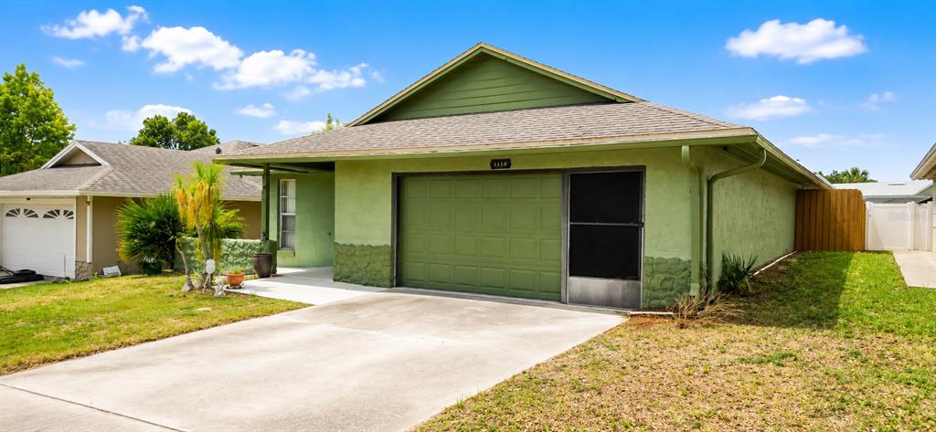 A green, single-story house with a two-car garage and a concrete driveway — 1350 PALO ALTO COURT, WINTER SPRINGS, FL