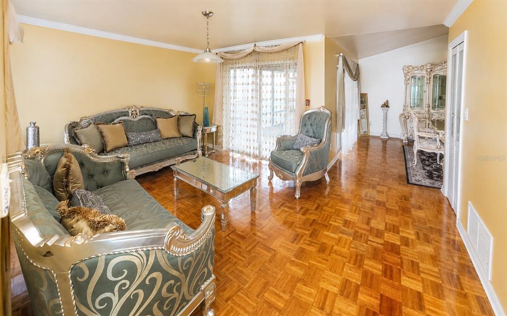 A living room with parquet wood floors, ornate teal furniture, and a glass coffee table — 1350 PALO ALTO COURT, WINTER SPRINGS, FL