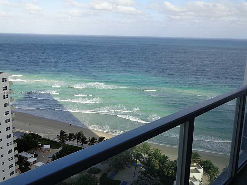A high-angle view of the ocean and beach from a balcony with a glass railing — 3101 S OCEAN DR # 2003, Hollywood FL 33019, HOLLYWOOD, FL