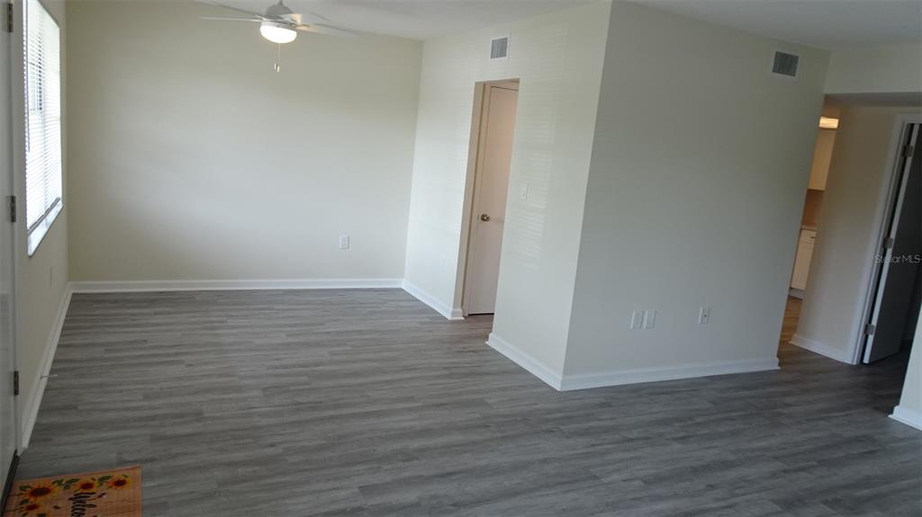 An empty room with light-colored walls, gray wood-look flooring, and a window with blinds — 8100 DR MARTIN LUTHER KING JR STREET N UNIT 105, ST PETERSBURG, FL