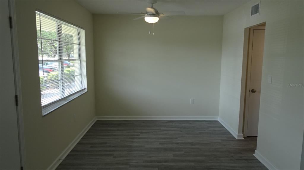 A dining area features a round wooden table, two chairs, and a console table — 8100 DR MARTIN LUTHER KING JR STREET N UNIT 105, ST PETERSBURG, FL