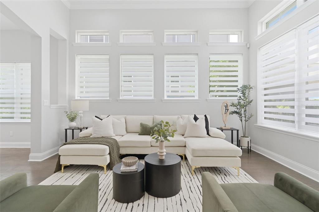 A bright living room features a cream sectional, two green armchairs, and multiple windows — 13856 ELIOT AVENUE, ORLANDO, FL