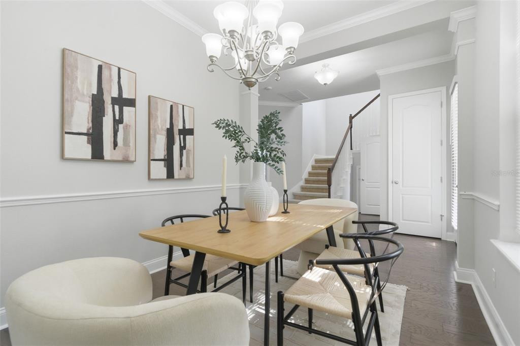 A dining room features a wooden table, modern chairs, a chandelier, and wall art — 13856 ELIOT AVENUE, ORLANDO, FL