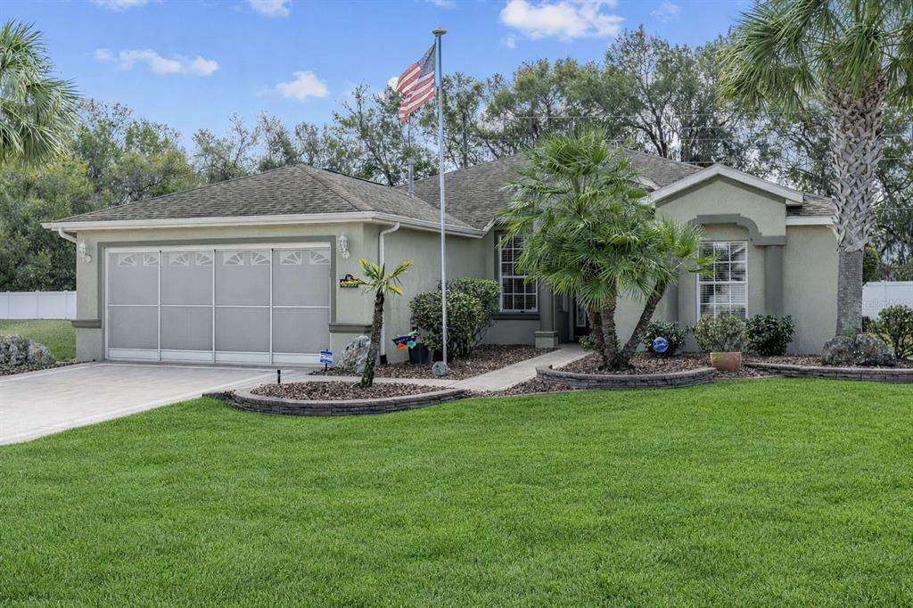A single-story house with a garage, a flag pole, and a landscaped front yard — 16339 SW 14TH AVE ROAD, OCALA, FL