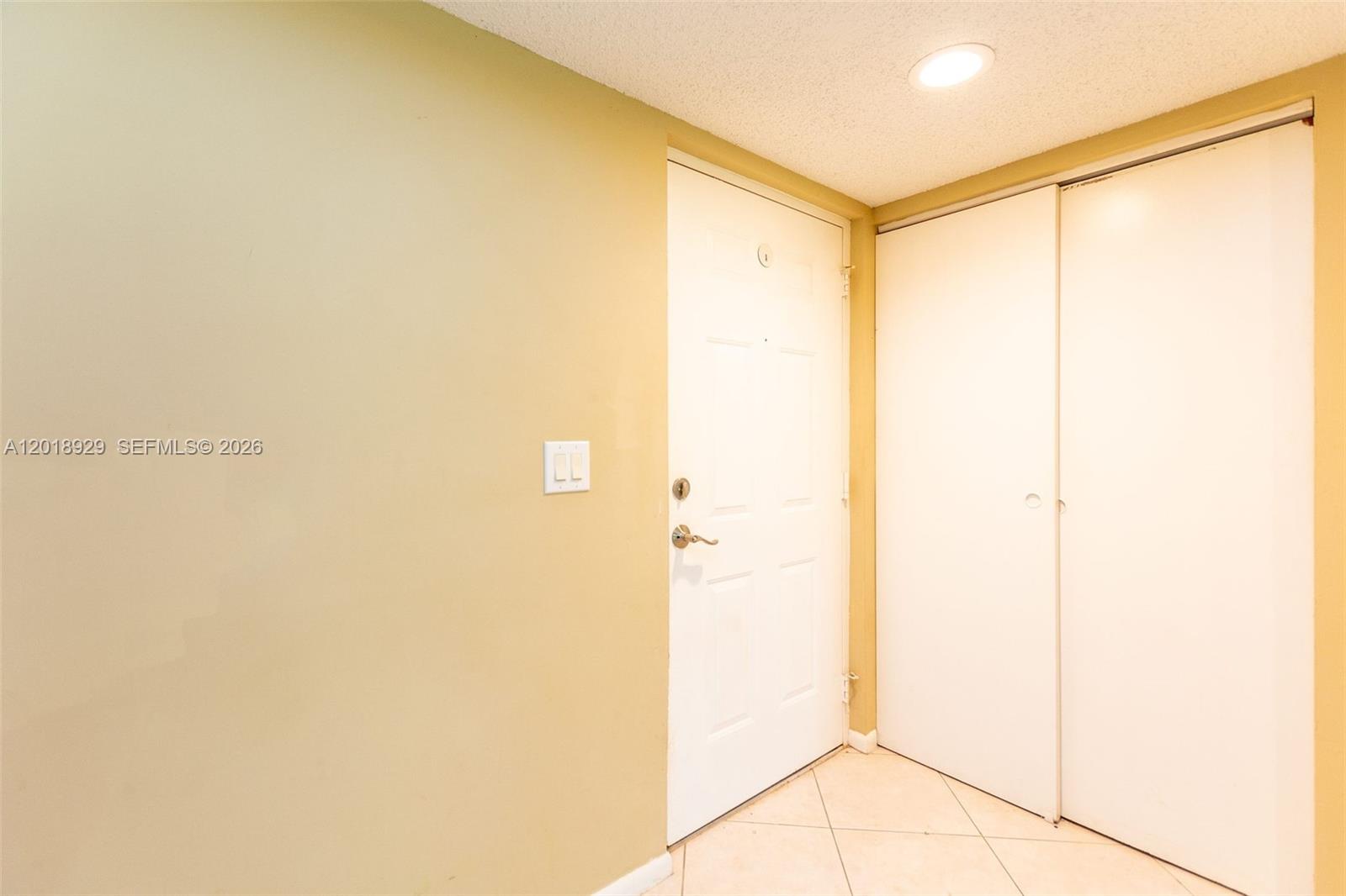 This interior view shows a doorway and a closet with white doors and tile flooring — 5721 Riverside Dr, Coral Springs FL 33067, CORAL SPRINGS, FL
