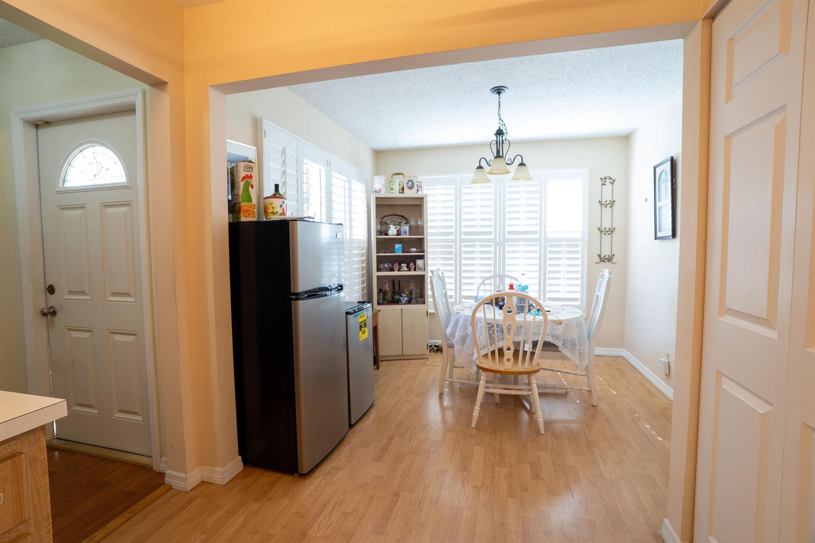 A dining area with a table, chairs, and a refrigerator sits next to an entryway — 6121 Rainbow Circle, FL 33463, FL