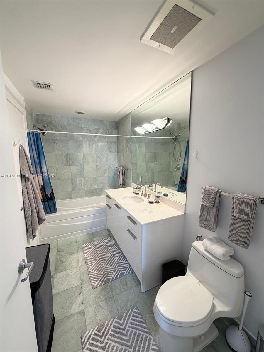 A bathroom features a white vanity, a bathtub with tiled walls, and a toilet — 1050 Brickell Ave # 1904, Miami FL 33131, MIAMI, FL