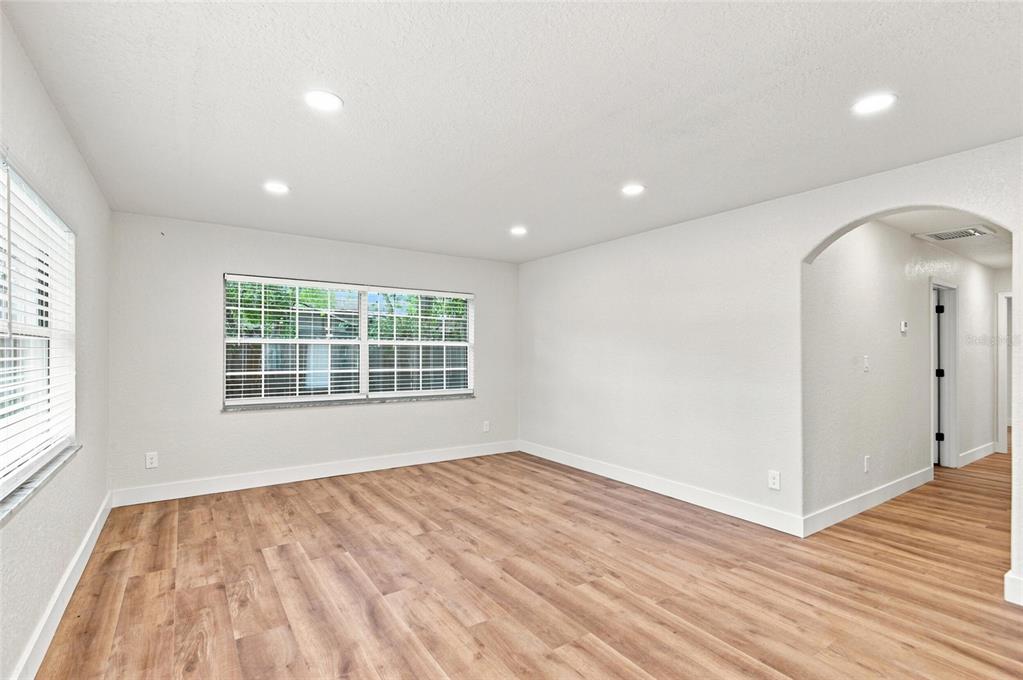 An empty room with white walls, recessed lighting, and wood-look flooring — 5511 CRAIG DRIVE, LAKELAND, FL
