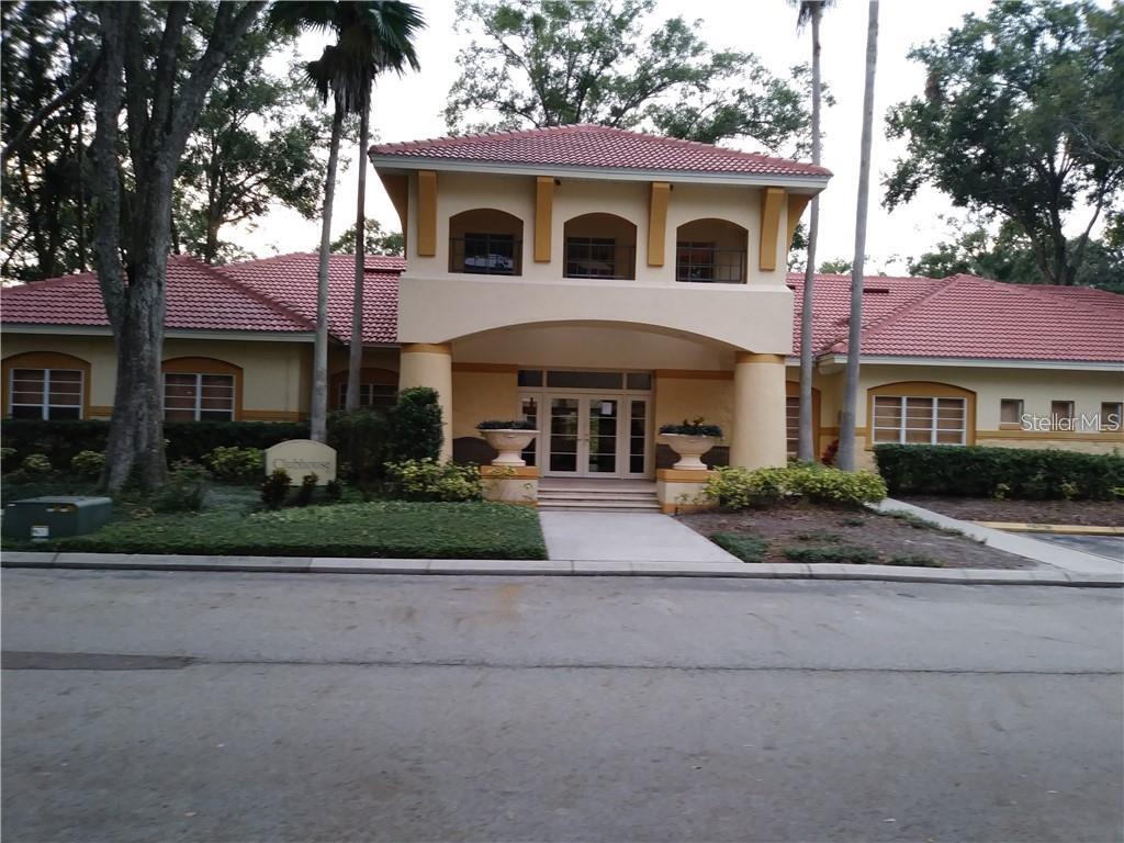 A low-rise clubhouse building with a red tile roof, arched windows, and a central entrance — 5620 PINNACLE HEIGHTS CIRCLE UNIT 305, TAMPA, FL