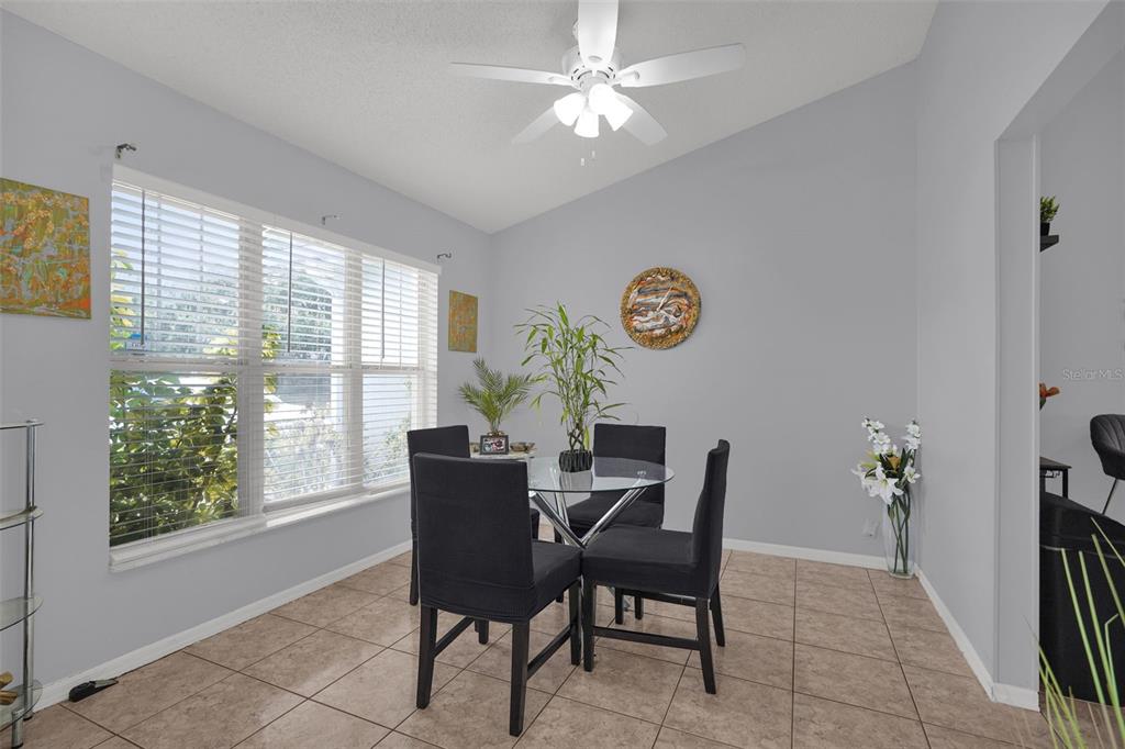 A dining area with tile floors, a glass table, four chairs, and a ceiling fan — 230 LYTTON CIRCLE, ORLANDO, FL