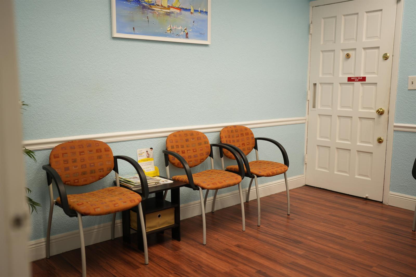 A waiting room features three orange patterned chairs, a small side table, and a white door — 2331 N State Rd 7 # 207, Lauderhill FL 33313, LAUDERHILL, FL