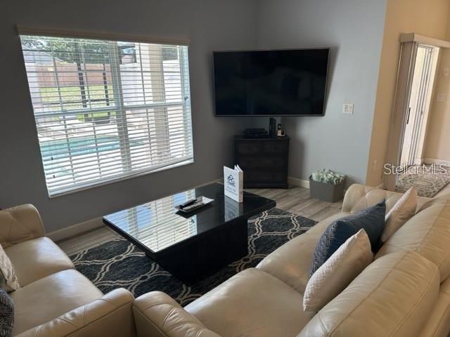 A living room features a leather sofa, a glass coffee table, and a wall-mounted television — 1608 MOON VALLEY DRIVE, DAVENPORT, FL