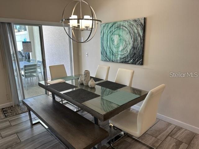 A dining room features a glass-topped table, a wooden bench, chairs, and a spherical chandelier — 1608 MOON VALLEY DRIVE, DAVENPORT, FL
