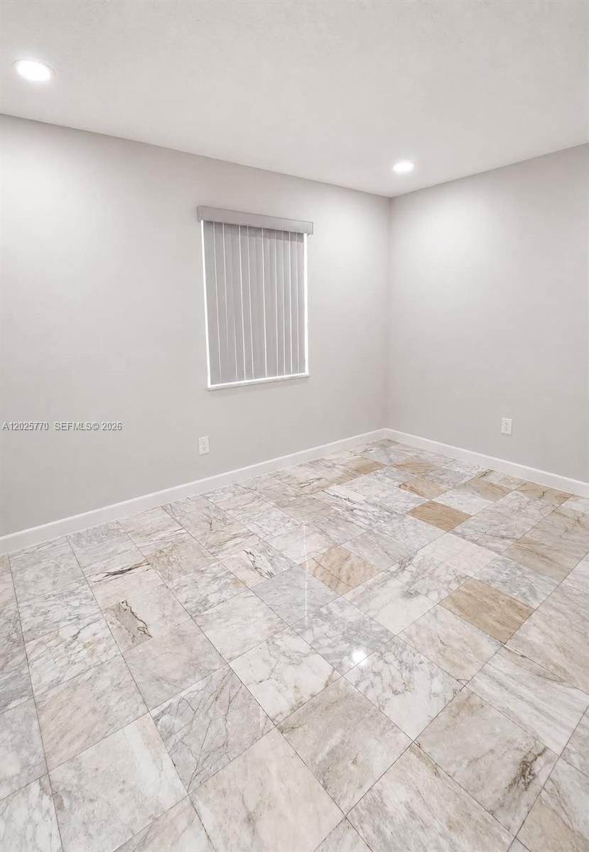 An empty room features light gray walls, recessed lighting, and polished marble tile flooring — 5735 Hayes St, Hollywood FL 33021, HOLLYWOOD, FL