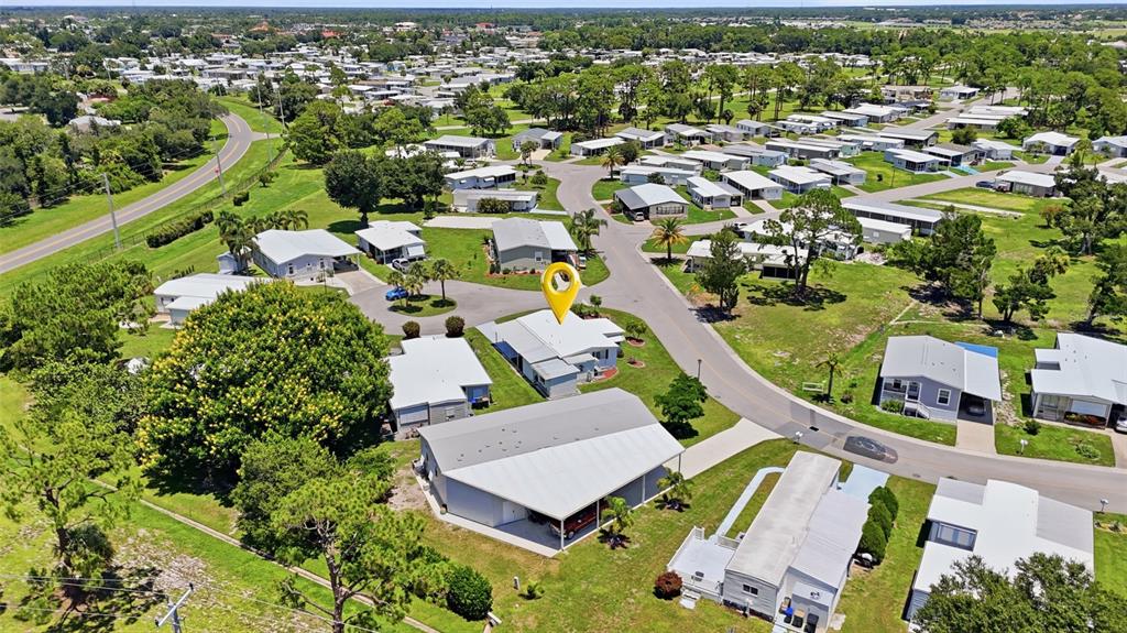 An aerial view shows a mobile home community with a yellow location pin on a house — 5058 PALENA BOULEVARD, NORTH PORT, FL
