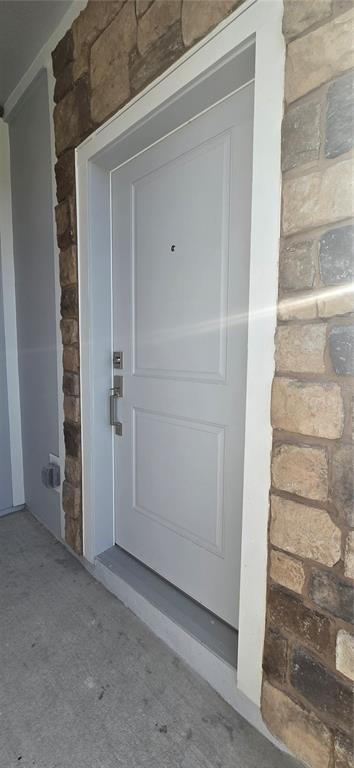 A light gray front door with a peephole is framed by stone veneer siding — 5560 MORANT BAY PATH, KISSIMMEE, FL