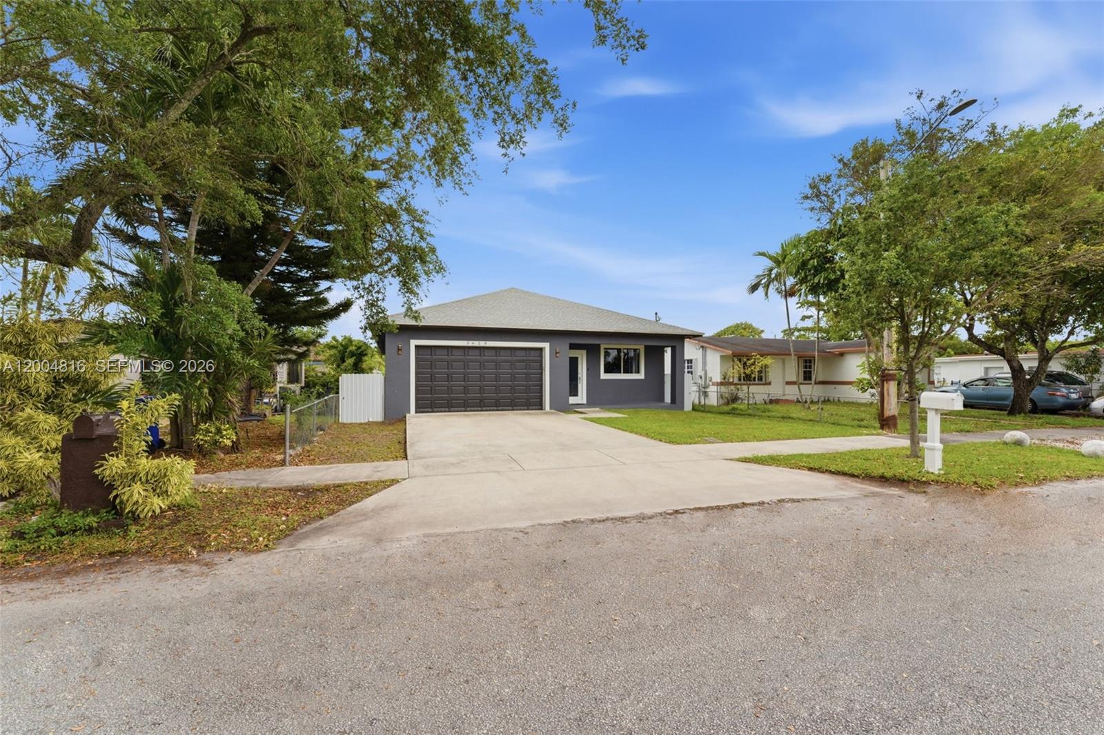 A gray single-story house features a dark garage door and a concrete driveway — 5628 Flagler St, Hollywood FL 33023, HOLLYWOOD, FL