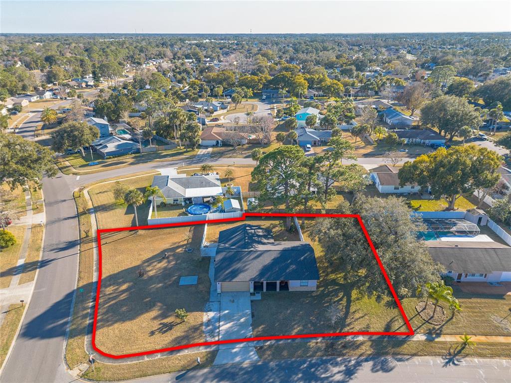 An aerial view shows a single-story house with a large yard outlined in red — 1210 MELLISA DRIVE, PORT ORANGE, FL