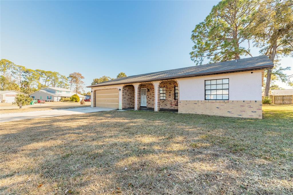 A single-story house with a brick facade, arched entryway, and a two-car garage — 1210 MELLISA DRIVE, PORT ORANGE, FL