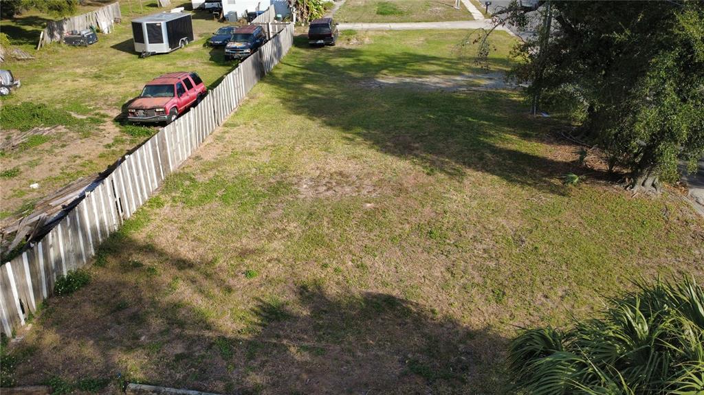 An aerial view shows a vacant, grassy rectangular lot bordered by a wooden fence — 4902 E 18TH AVENUE, TAMPA, FL