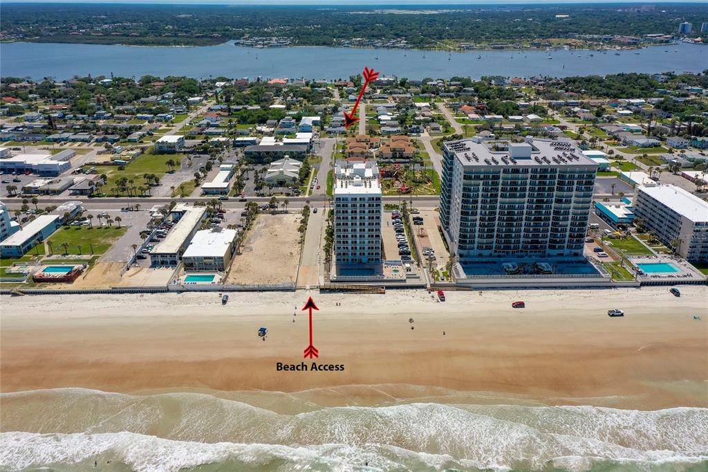 An aerial view shows a beach with a public access path between two large buildings — 130 BOYNTON BOULEVARD, DAYTONA BEACH, FL