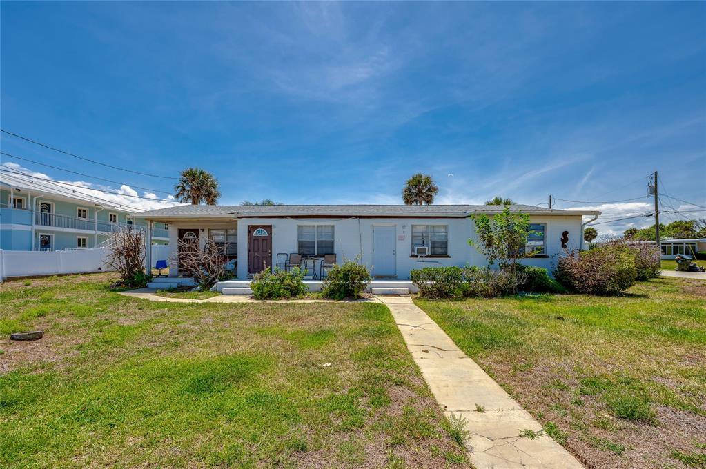 A single-story white duplex with a flat roof and a concrete walkway in front — 130 BOYNTON BOULEVARD, DAYTONA BEACH, FL
