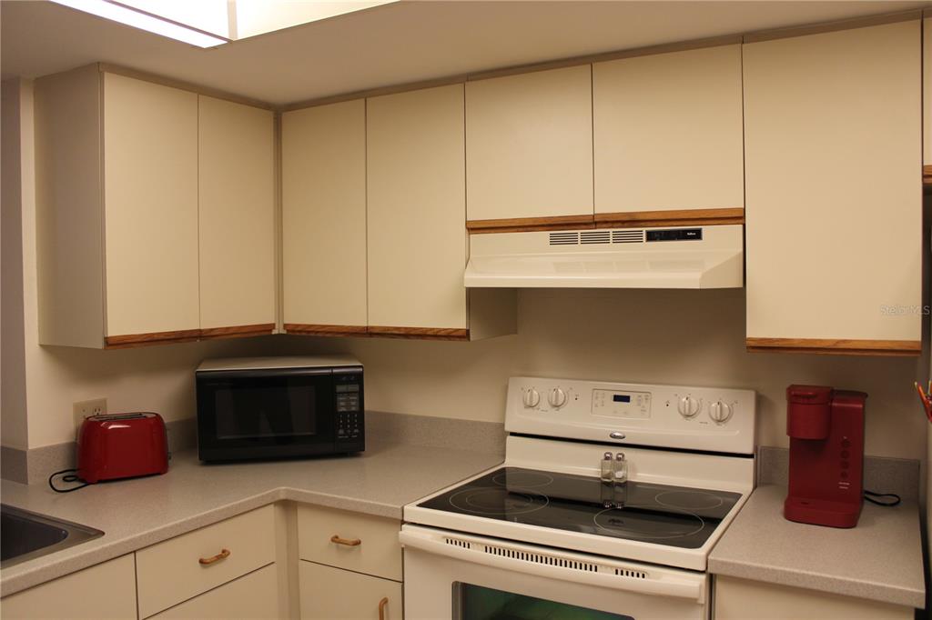 A kitchen featuring light-colored cabinets, a white electric range, and a grey countertop — 6304 POINTE WEST BOULEVARD UNIT A309, BRADENTON, FL