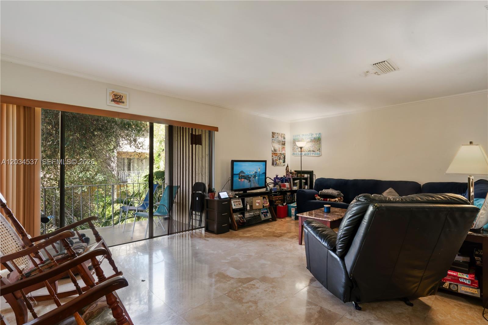 A living room features tile floors, a dark leather recliner, a sofa, and a balcony — 9371 Fontainebleau Blvd # I204, Miami FL 33172, MIAMI, FL