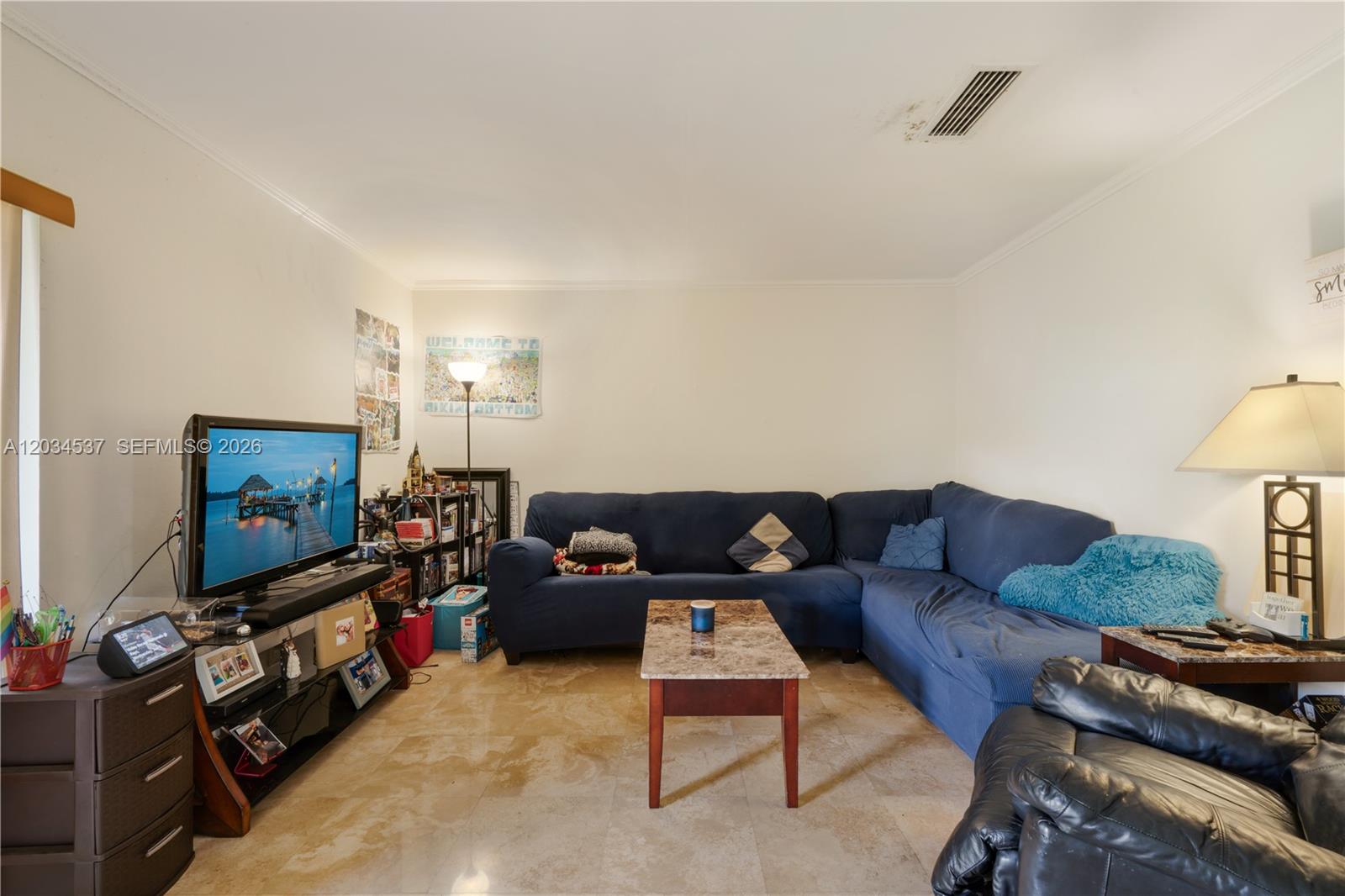 A living room features a blue sectional sofa, a marble-topped coffee table, and tile flooring — 9371 Fontainebleau Blvd # I204, Miami FL 33172, MIAMI, FL