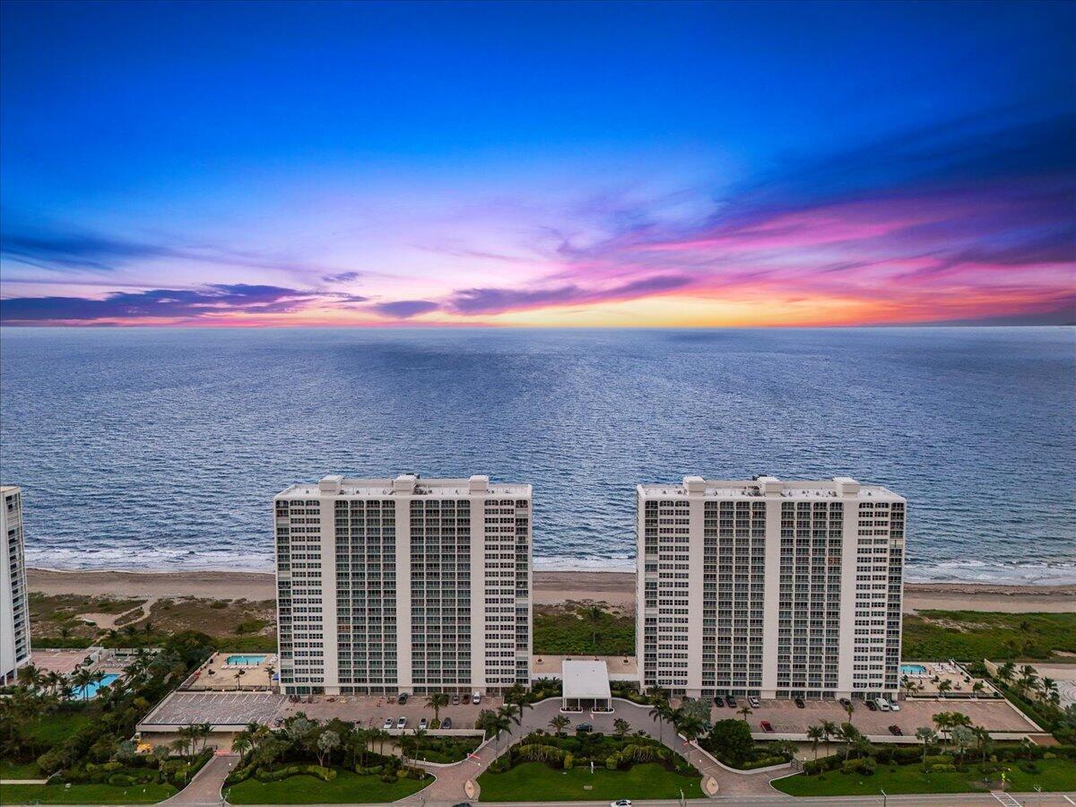 An aerial view shows two tall residential buildings situated along a sandy beach at sunset — 2800 S Ocean Boulevard Unit 2f, Boca Raton FL 33432, BOCA RATON, FL