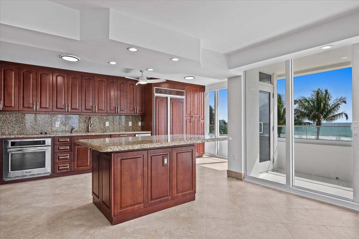 A kitchen with dark wood cabinets, granite countertops, a center island, and ocean views — 2800 S Ocean Boulevard Unit 2f, Boca Raton FL 33432, BOCA RATON, FL
