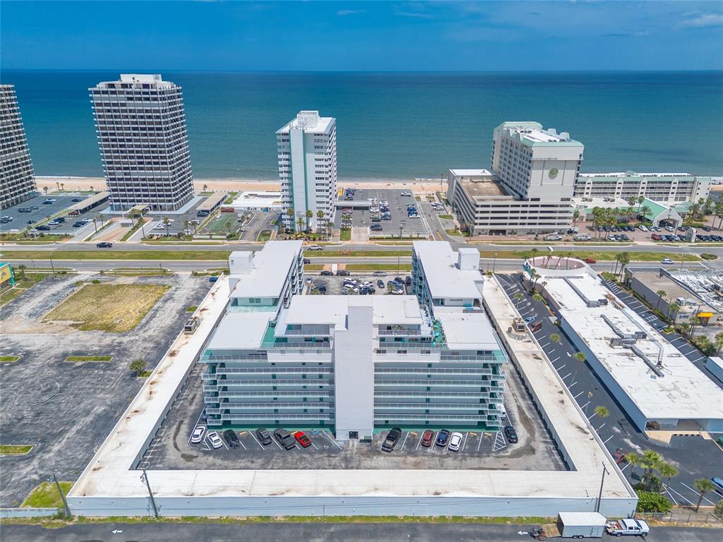 An aerial view shows a multi-story white apartment building surrounded by a parking lot — 2727 N ATLANTIC AVENUE UNIT 4190, DAYTONA BEACH, FL