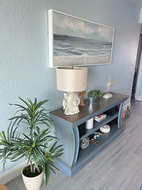 A blue console table with a lamp and coastal art sits against a light blue wall — 8150 BRENT STREET UNIT 734, PORT RICHEY, FL