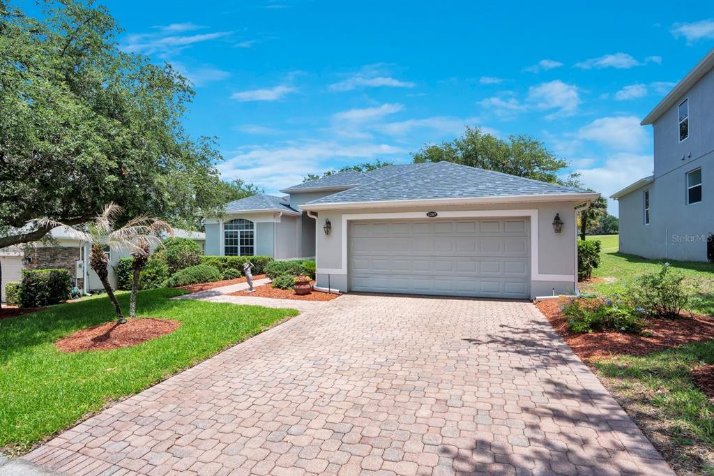 A screened-in swimming pool overlooks a golf course with mature trees in the background — 1207 LEGENDARY BOULEVARD, CLERMONT, FL