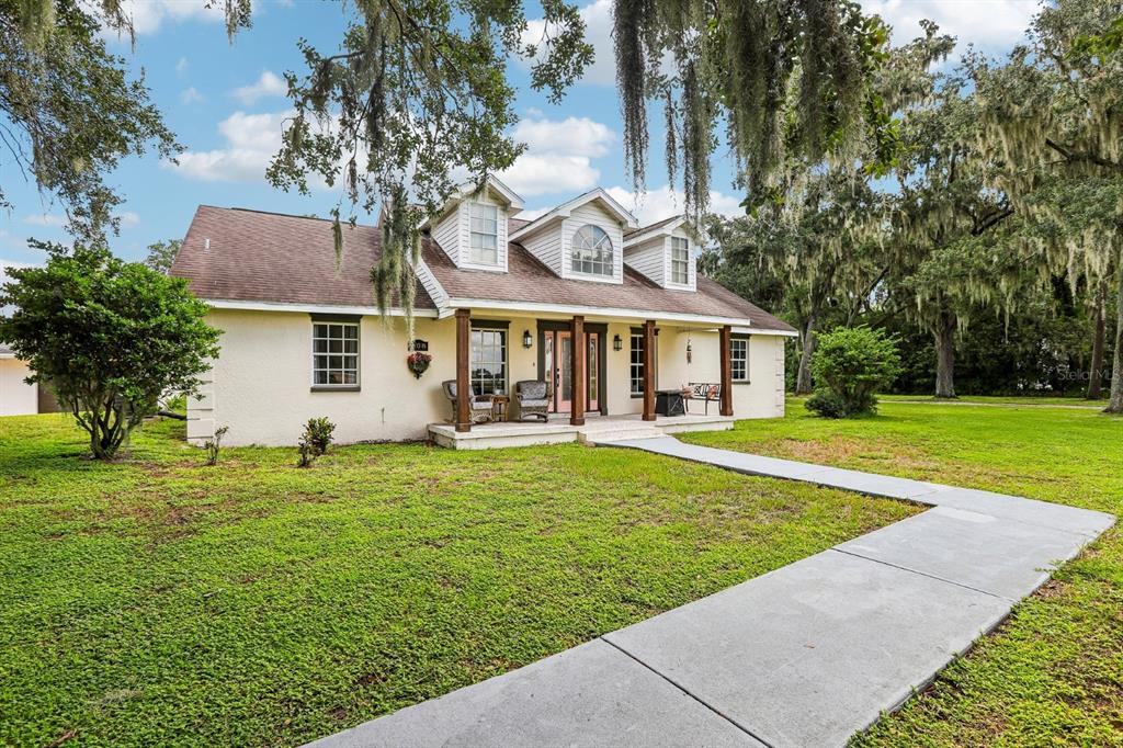 A single-story house with a covered porch, dormer windows, and a concrete walkway — 408 HOLLOWAY ROAD, PLANT CITY, FL