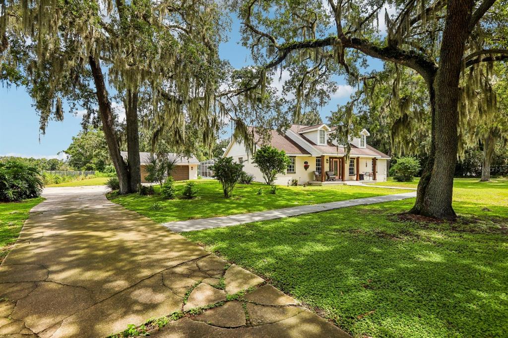 A single-story house with a driveway and large oak trees draped in Spanish moss — 408 HOLLOWAY ROAD, PLANT CITY, FL