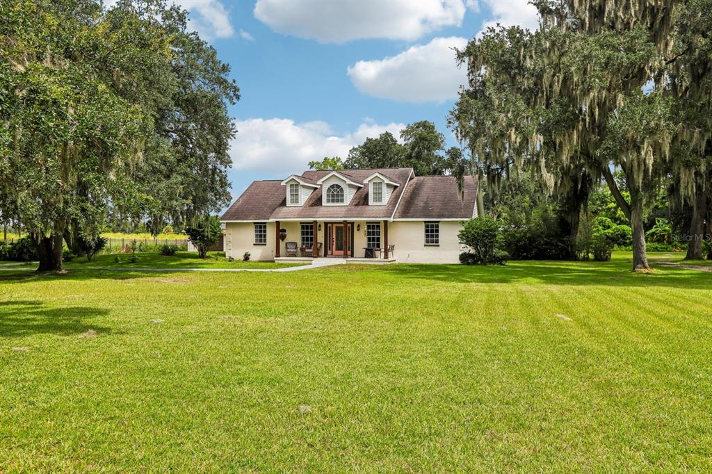 A single-story house with three dormers and a front porch sits on a grassy lawn — 408 HOLLOWAY ROAD, PLANT CITY, FL