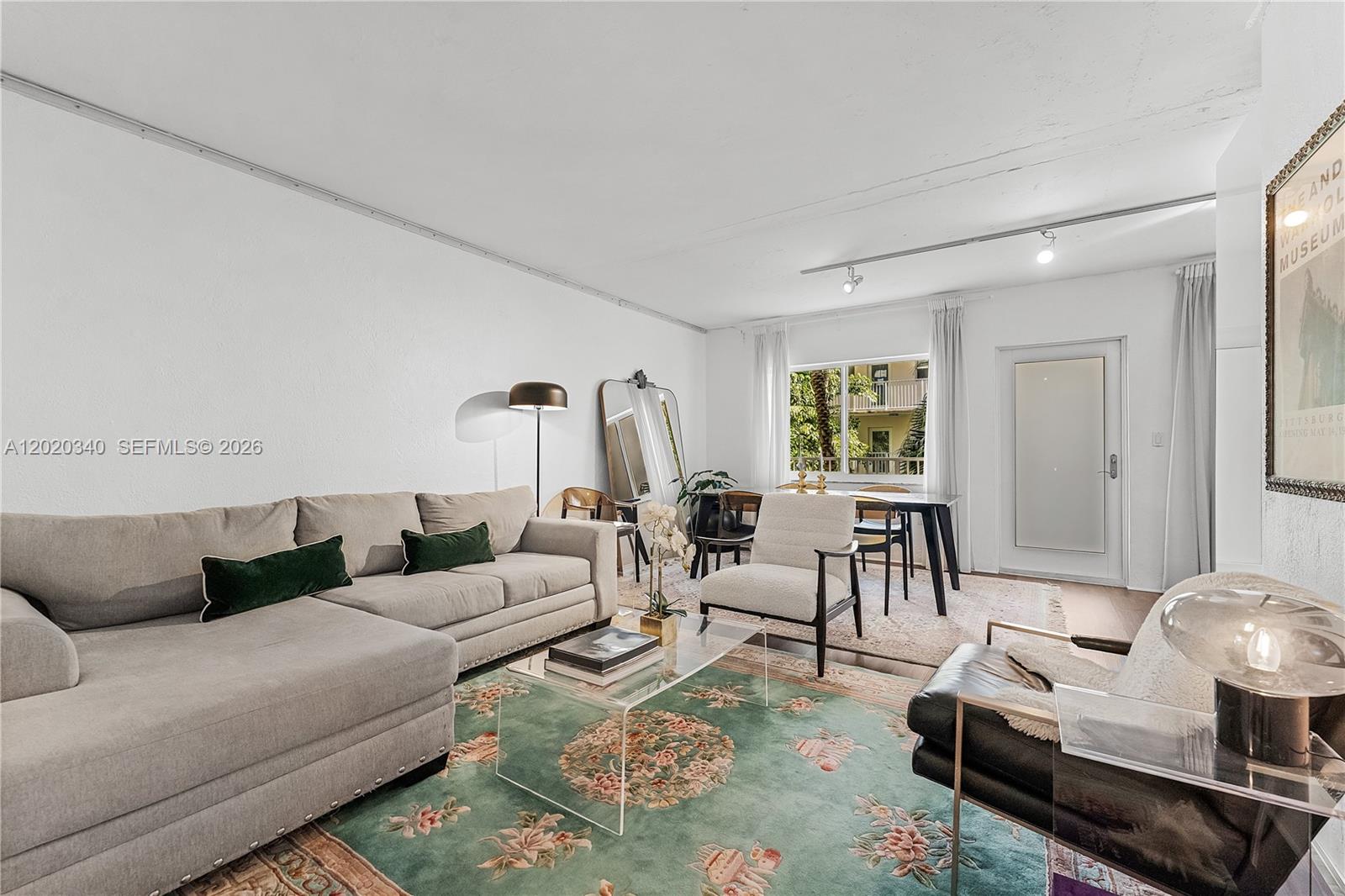A living room features a sectional sofa, a patterned rug, and a dining area — 1420 Pennsylvania Ave # 201, Miami Beach FL 33139, MIAMI BEACH, FL